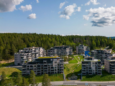 Bo godt med fantastisk utsikt i attraktivt sameie! Romslig og vestvendt balkong, garasjeplass m/lader og takterrasse!