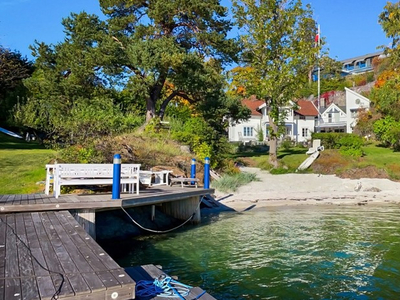 Eksepsjonell strandeiendom med herskapelig bolig, egen badestrand og dypvannsbrygge. Over 2,3 mål ytterst på Langodden.