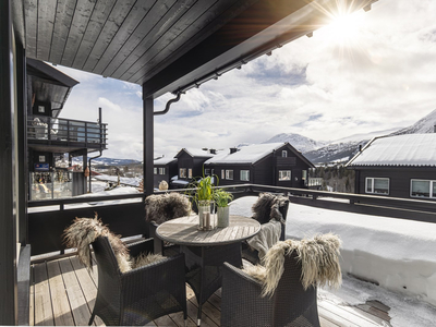 Stilren hjørneleilighet med stor solrik terrasse. Flott fjellutsikt samtidig midt i sentrum av Hemsedal. Garasjeplass.