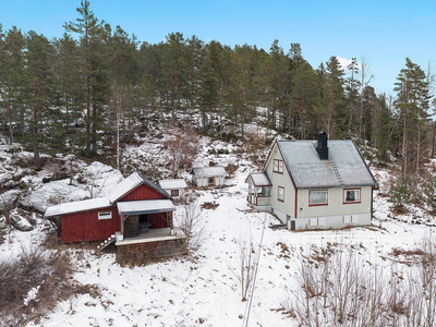 Sørvest vendt enebolig og uthus med oppgraderingsbehov.