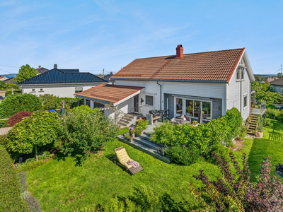 Attraktiv og stor enebolig på Tveiten med nydelig hage, garasje og carport - 4 soverom, 2 bad, loft- og kjellerstue!