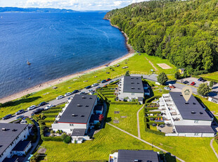 Rekkehus nederst i Refsnesalleen med flott fjordutsikt. Mulighet for 3 sov. Solfylte terrasser. Få meter til stranden.