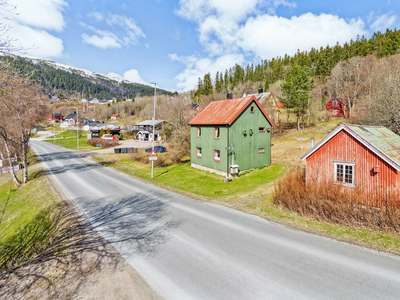 Eldre enebolig med romslig tomt og eldre uthus. Butikk, barnehage og skole i nærområdet.