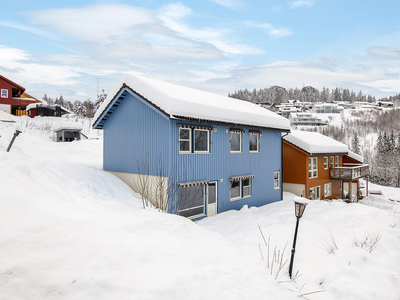 Enebolig over to plan beliggende litt opp for sentrum. Vestvendt med gode solforhold. Tre soverom.