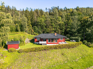 Enebolig med en landlig og idyllisk beliggenhet, men meget sentralt i Lier. Tre soverom. Garasje. 1,5 mål tomt.