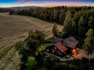 Landlig idyll med laftet hus og dobbel garasje - Herlig beliggenhet i jorde- og skogkanten - Nærhet til E-18 - Solrikt!