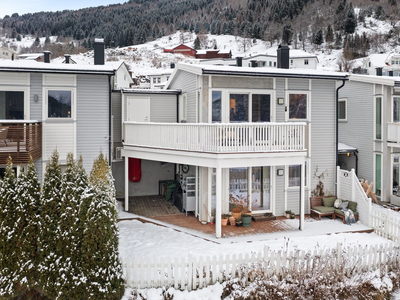 Solrik og attraktiv einebustad i rekke med fantastisk utsikt. Sjarmerande og koseleg uteområde. Carport og boder