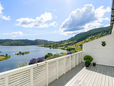 Flott halvpart av tomannsbolig med nydelig utsikt over Kalandsvannet. Gode solforhold på terrasse og altan. 4 soverom!