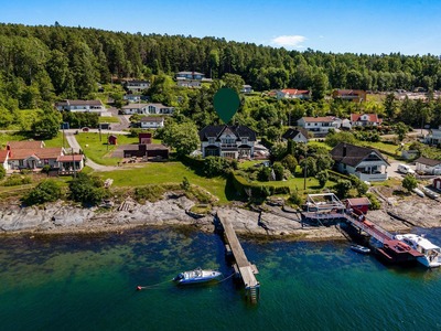 Praktfull og idyllisk bolig med en suveren beliggenhet rett ved fjorden. Solrik terrasse på 140 kvm. Heis. Egen brygge.