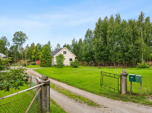 Enebolig i landlige omgivelser med stor tomt og garasjebygg.