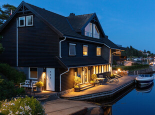 Stor strandeiendom med brygge og lune uteplasser. Meget gode solforhold. Dobbel garasje med loft