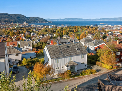 Klassisk villaeiendom med panoramautsikt og to utleiedeler. Gode solforhold og stor hage. Velholdt fasade.