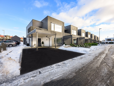 Stilig, moderne enderekkehus fra 2022 med flott terrasse, skjermet uteplass og parkering i carport. Stue med peisovn.