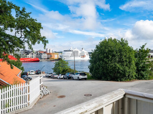 Selveierleilighet med næringslokale i kjeller, parkering og utsikt til havnebassenget.