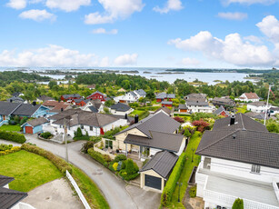 Velholdt og innholdsrik enebolig med garasje, solrike terrasser og panorama sjøutsikt. Ettertraktet område for familien!