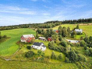 Sjarmerende småbruk med velholdt enebolig, fjøs/låve, kårbolig og vedskjul/garasje - Vidstrakt utsikt og gode solforhold