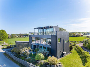 Nyere villa med godt design og høy kvalitet, utsikt og gode solforhold, skjermet hage med hagestue. Garasje og carport.