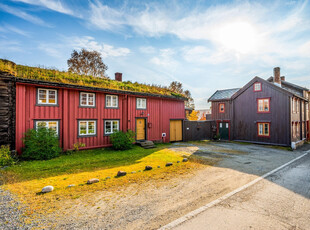 Spennende bygård i Røros sentrum, øverst i Kjerkgata. Flott bakgård med to uthus. Godt med parkering på egen tomt.