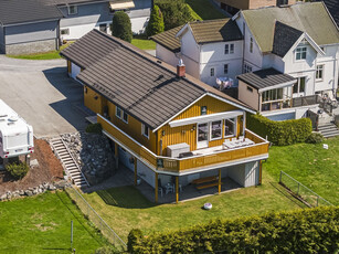 Velholdt og tiltalende bolig med 2 innganger. Solrik og usjenert tomt, grensende til friområde. Garasje og carport.