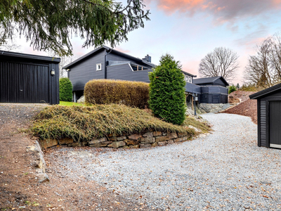 Meget koselig familiebolig over en flate med stor, solrik hage, svømmebasseng og trivelige uteplasser. Flere garasjer.