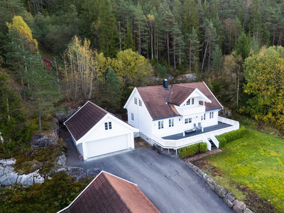 Innholdsrik enebolig på usjenert tomt med kveldssol. Stor garasje.