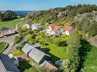 Flott eiendom med sjarmerende bolighus, fin hage med drivhus, dobbel garasje med loft, løe og naust med brygge!