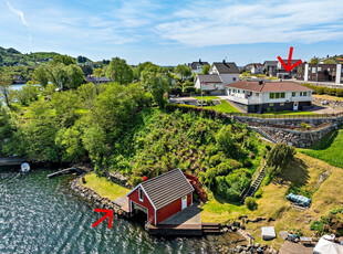 Flott eiendom ved sjøen med bolighus på ett plan, hage, garasje, carport og naust!