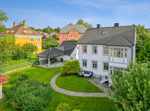 Flott og herskapelig bolig med sentral beliggenhet, fin hage og hyggelige uteplasser. Meget god standard. Dobbelgarasje