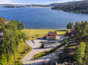 Idyllisk beliggende småbruk med ca. 115 meter strandlinje - Låve - Store gressarealer