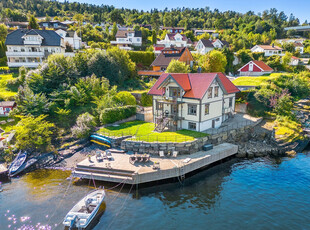 Fantastisk eiendom med strandlinje, nydelig sjøutsikt, solrike uteplasser, egen dypvannsbrygge- og båtplass. Utleiedel.