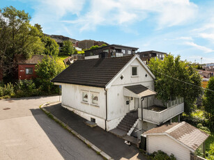 Sentrumsnær enebolig med renoveringsbehov, tilbaketrukket inntil St. Hansfjellet. 2 bad, 2 kjøkken.