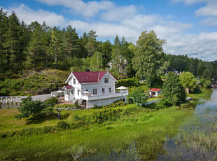 Sjarmerende sveitserbolig med idyllisk beliggenhet og 70m vannlinje. Solrik tomt med brygge og badeplass. Ingen boplikt!