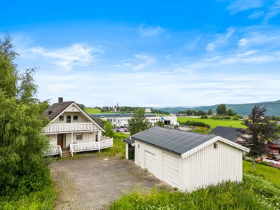 Romslig og innholdsrik enebolig. Solrik og flat tomt på over 1 mål. Dobbelgarasje.